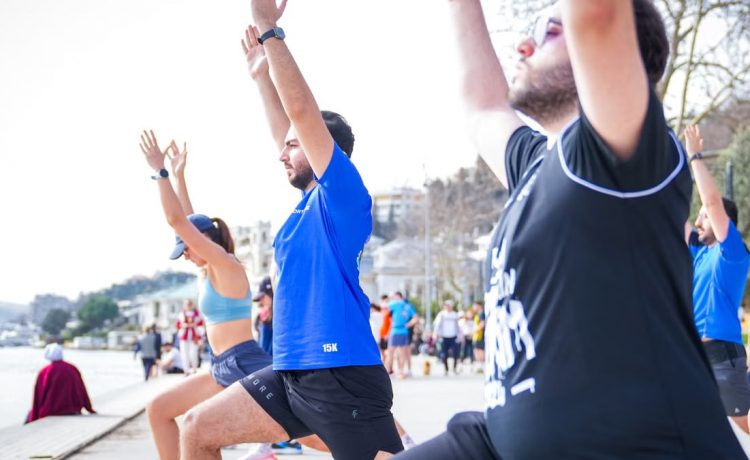 Group performing yoga outdoors along the scenic waterfront in İstanbul, Türkiye.